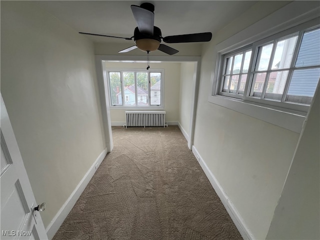 hall featuring radiator and light colored carpet