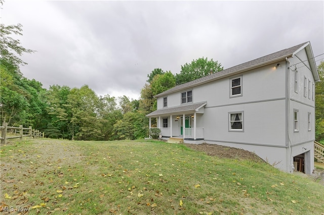 back of house featuring a yard and covered porch