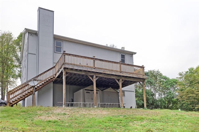 rear view of property with a wooden deck and a lawn