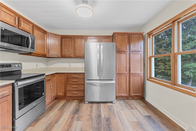 kitchen featuring appliances with stainless steel finishes, light wood-type flooring, and plenty of natural light