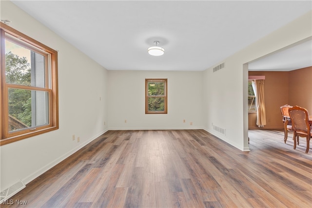 unfurnished room with plenty of natural light and hardwood / wood-style floors