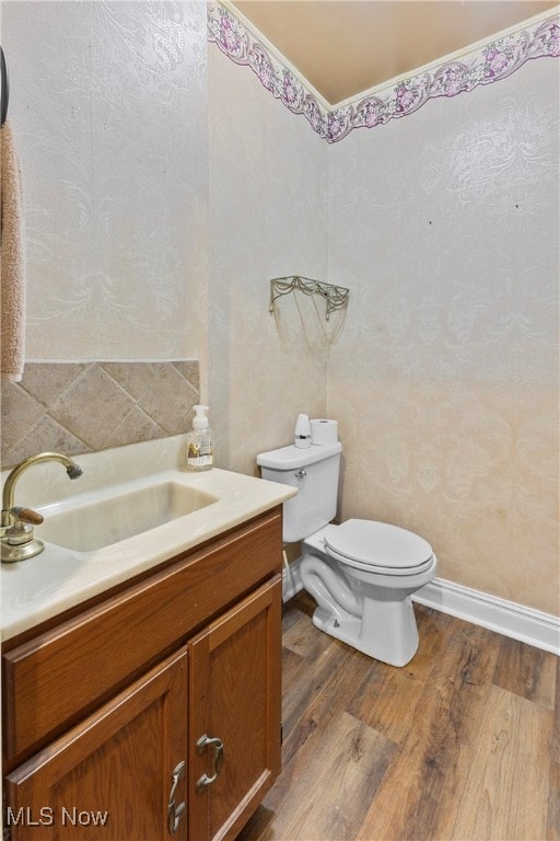 bathroom featuring wood-type flooring, vanity, and toilet