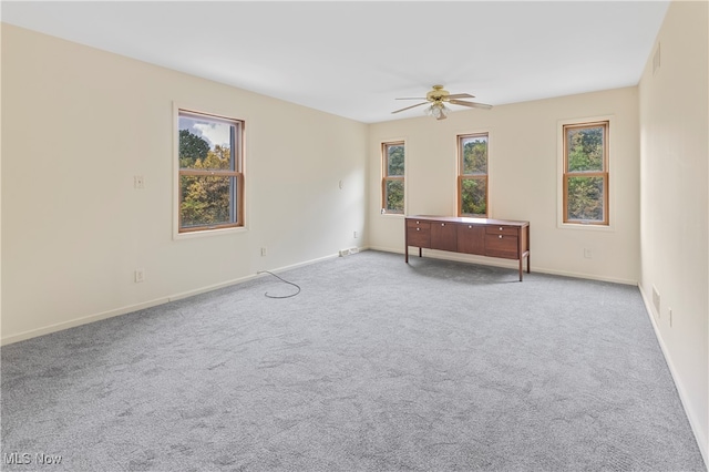 carpeted empty room featuring ceiling fan and a healthy amount of sunlight