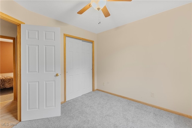 unfurnished bedroom with light carpet, a closet, and ceiling fan