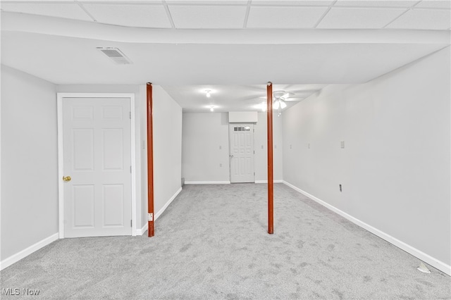 basement with a drop ceiling and light colored carpet