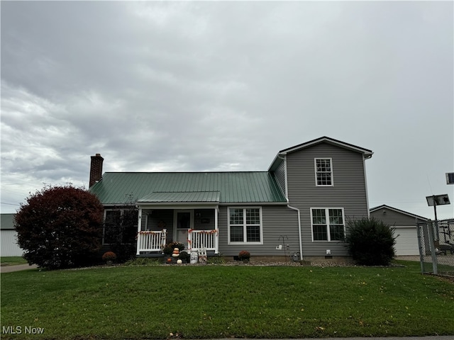 view of front of house featuring a garage, a front lawn, and covered porch