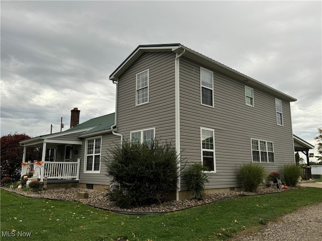 view of home's exterior featuring a porch and a yard