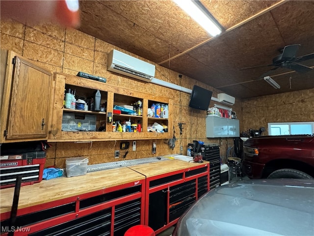 garage with a workshop area, ceiling fan, and a wall mounted AC