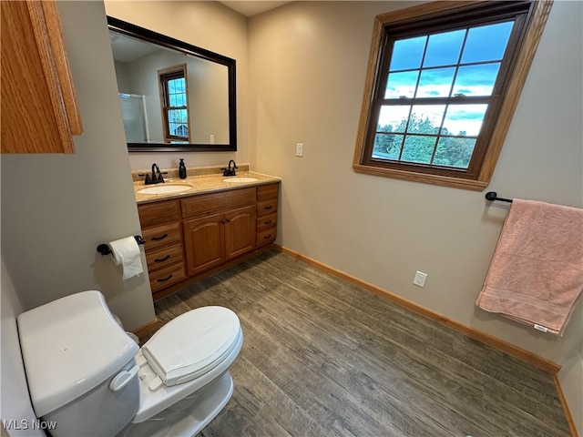 bathroom with vanity, plenty of natural light, toilet, and hardwood / wood-style flooring