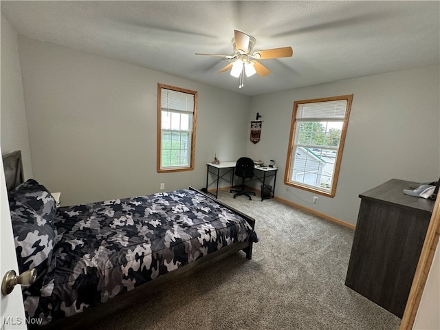 bedroom featuring carpet, multiple windows, ceiling fan, and a textured ceiling