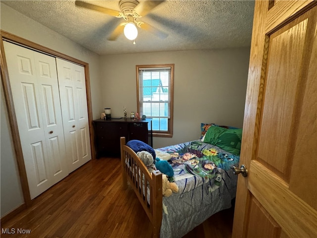 bedroom featuring a closet, dark hardwood / wood-style floors, ceiling fan, and a textured ceiling