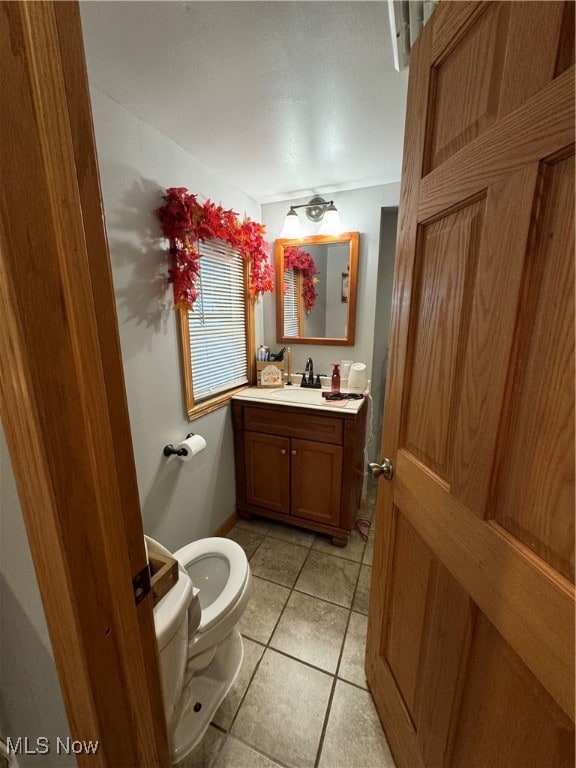 bathroom with vanity, toilet, and tile patterned floors