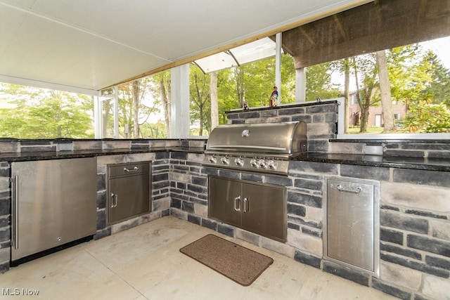 view of patio with an outdoor kitchen and a grill