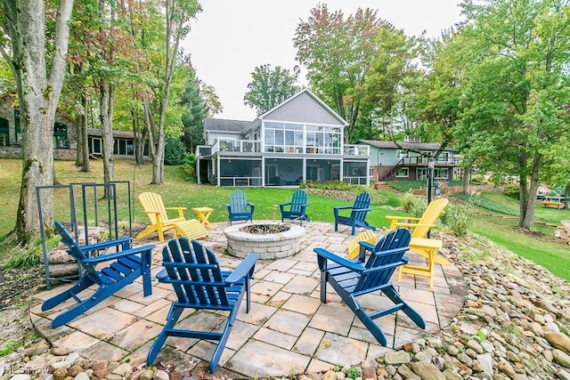 view of patio / terrace with a fire pit, a sunroom, and stairs
