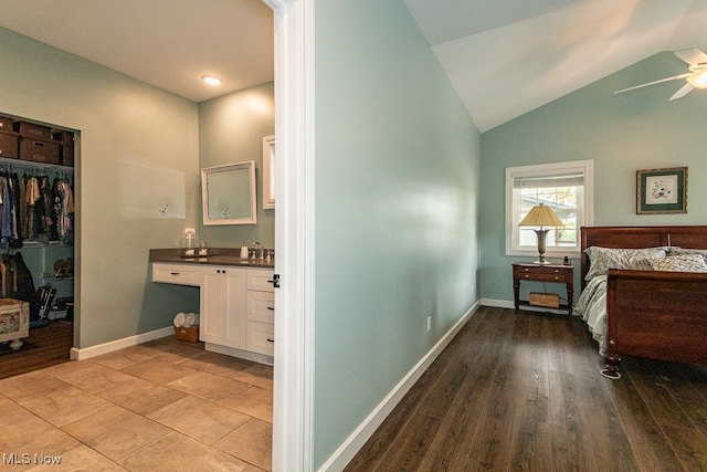 bedroom featuring lofted ceiling, a closet, light hardwood / wood-style flooring, a walk in closet, and ceiling fan