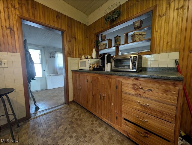 10206 Gillespie Run Rd, Petroleum, WV 26161 - kitchen with open shelves, dark countertops, white microwave, wood walls, and brown cabinets