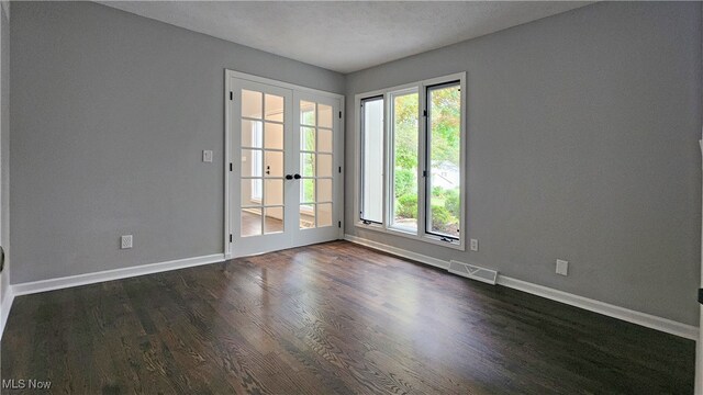 unfurnished room featuring a textured ceiling, french doors, and dark hardwood / wood-style flooring