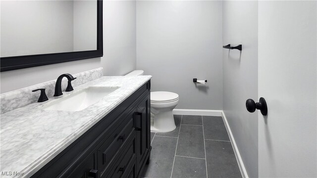 bathroom featuring vanity, toilet, and tile patterned floors