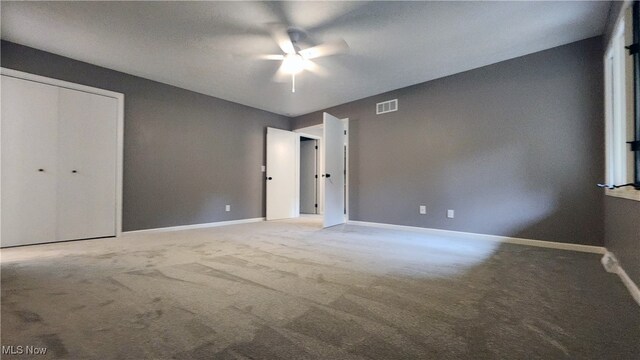 unfurnished bedroom featuring a closet, carpet, and ceiling fan