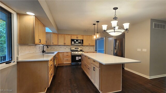 kitchen with pendant lighting, dark hardwood / wood-style floors, a kitchen island, an inviting chandelier, and stainless steel appliances