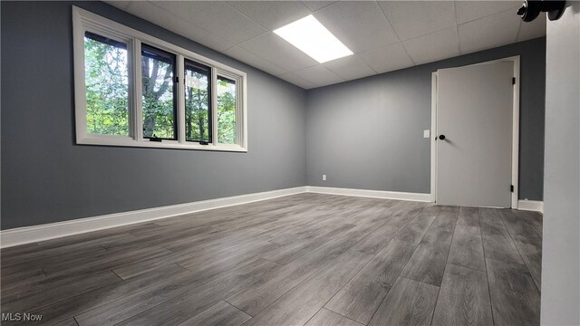 spare room with wood-type flooring and a paneled ceiling