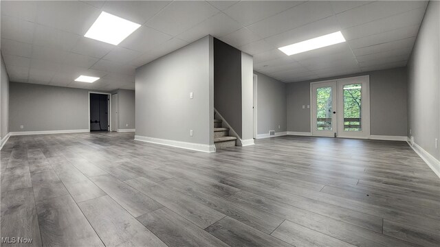 interior space with a drop ceiling and hardwood / wood-style floors