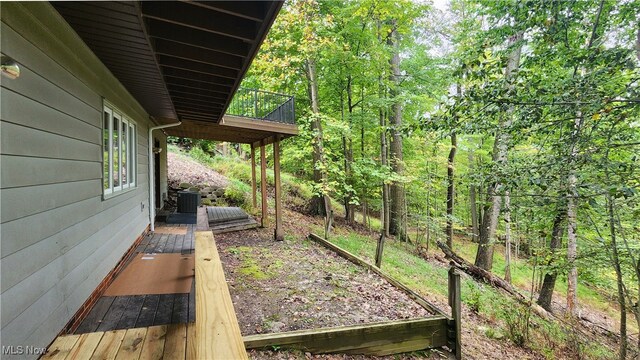 view of yard with a wooden deck and central air condition unit