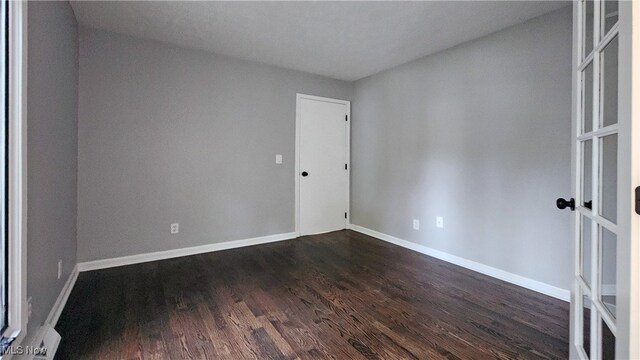 spare room featuring dark wood-type flooring