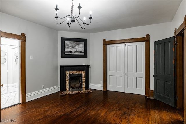 interior space featuring dark hardwood / wood-style floors, a chandelier, and a high end fireplace