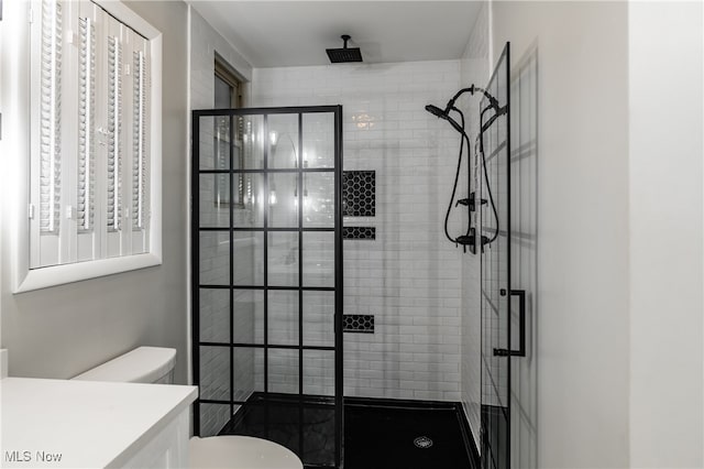 bathroom featuring vanity, toilet, and a shower with shower door