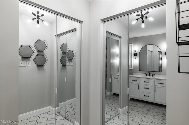 bathroom with an inviting chandelier, tile patterned floors, and vanity