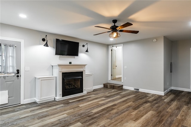 unfurnished living room featuring ceiling fan and hardwood / wood-style floors