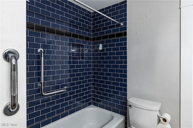 bathroom featuring tiled shower / bath combo and toilet