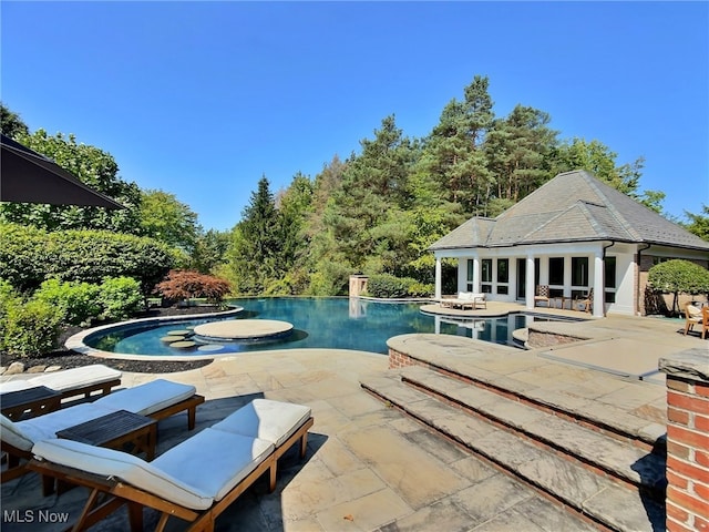 view of swimming pool featuring a patio area, a hot tub, and an outdoor structure