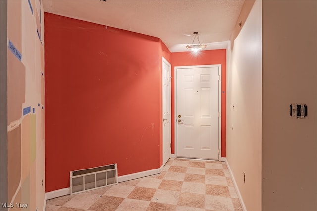 doorway with a textured ceiling