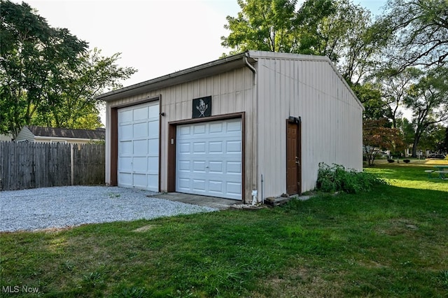 garage featuring a lawn and wood walls