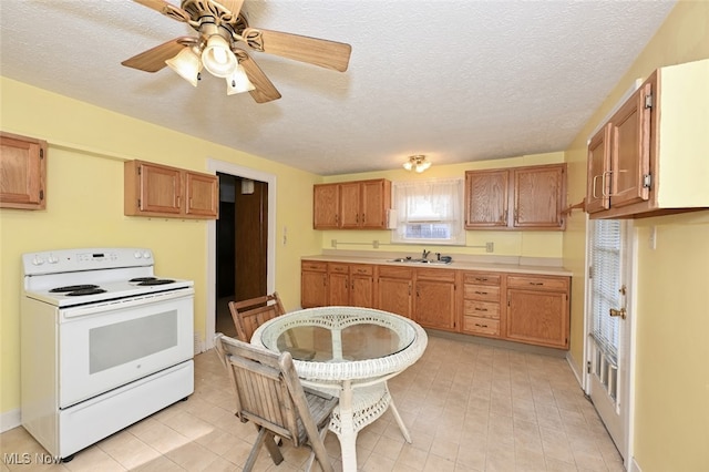 kitchen with ceiling fan, white range with electric cooktop, a textured ceiling, and sink