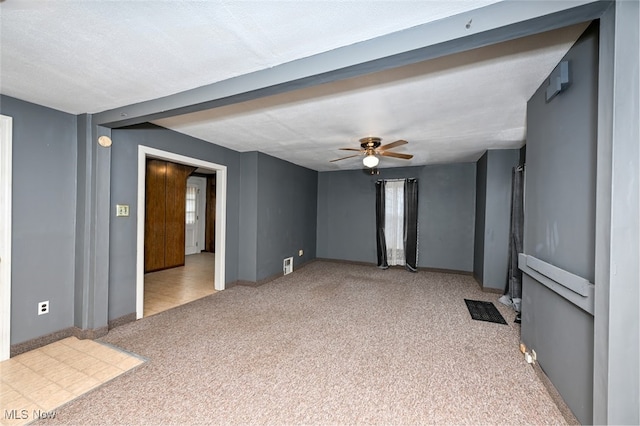 carpeted spare room featuring a textured ceiling and ceiling fan