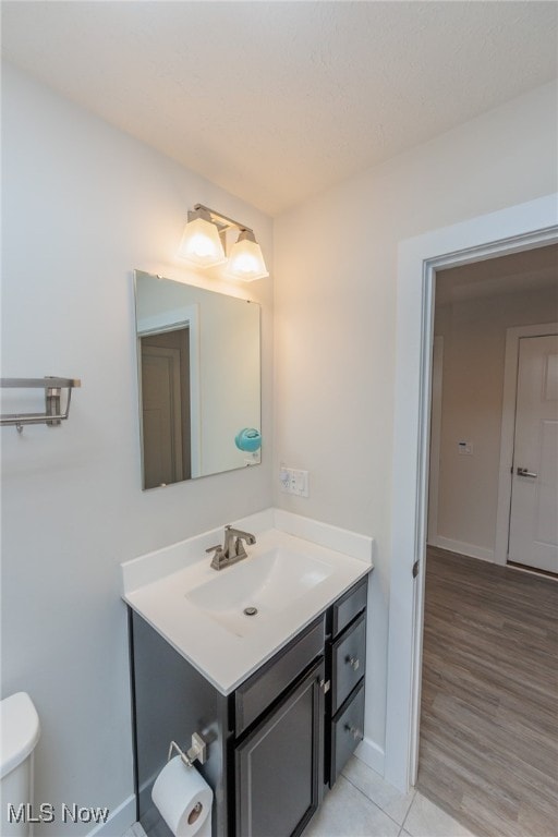 bathroom featuring vanity, toilet, and hardwood / wood-style floors