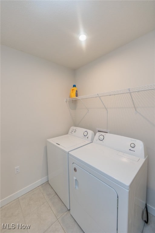 laundry area featuring light tile patterned floors and washer and clothes dryer