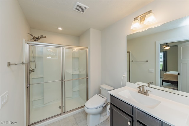 bathroom with walk in shower, vanity, tile patterned flooring, and toilet