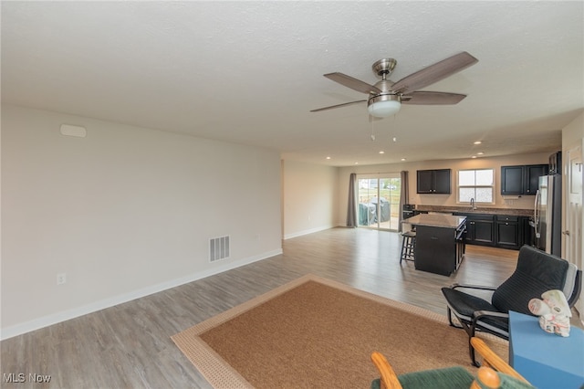 unfurnished living room featuring light wood-type flooring and ceiling fan