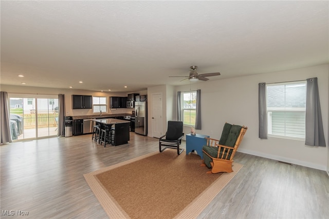 sitting room with ceiling fan, sink, and light hardwood / wood-style floors