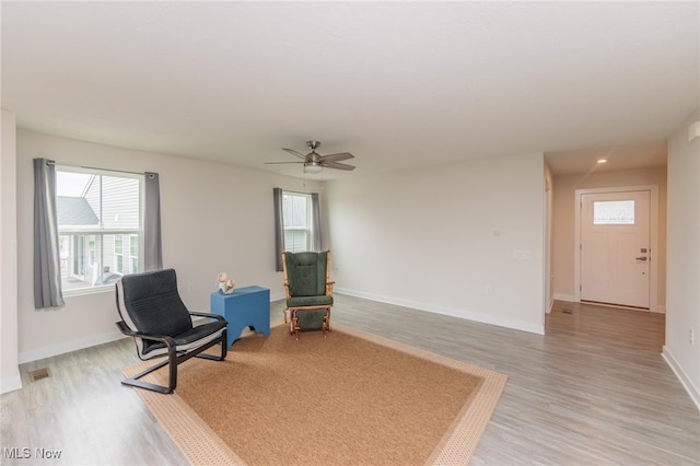 sitting room with ceiling fan and light hardwood / wood-style flooring