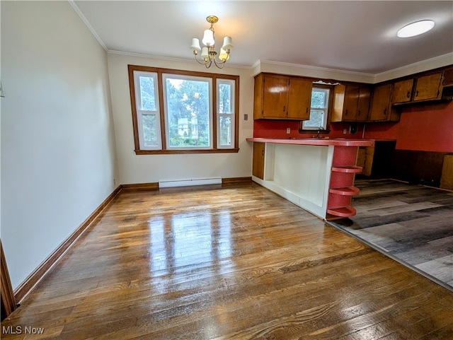 kitchen featuring baseboard heating, ornamental molding, hardwood / wood-style floors, and a notable chandelier