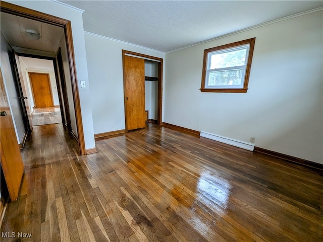 unfurnished bedroom with a baseboard heating unit, a closet, a textured ceiling, dark hardwood / wood-style flooring, and ornamental molding