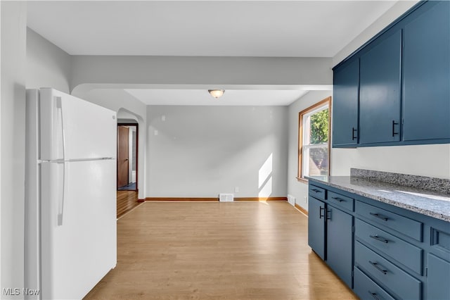 kitchen featuring light hardwood / wood-style floors, blue cabinets, and white refrigerator