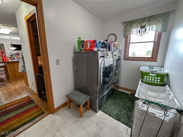 laundry area featuring a textured ceiling and washing machine and clothes dryer