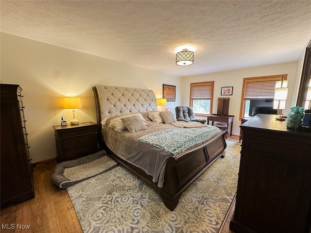 bedroom featuring a textured ceiling and hardwood / wood-style flooring