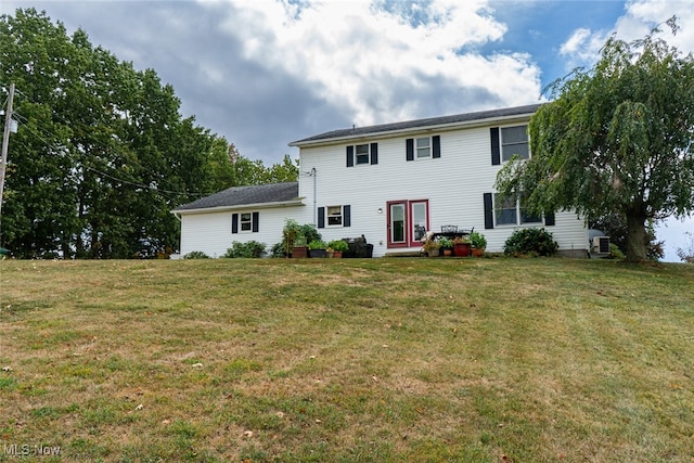 colonial-style house featuring a front lawn